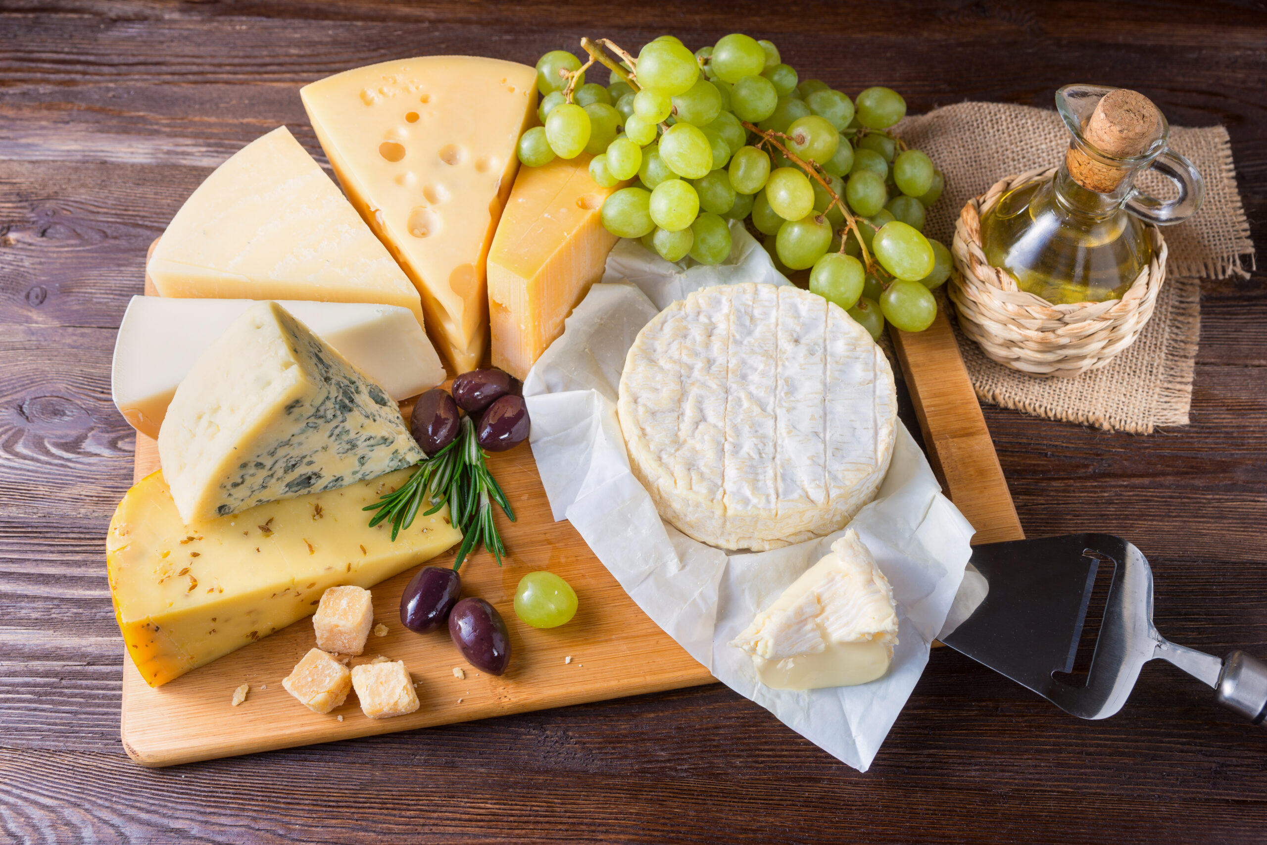Cheese plate served with grapes on a wooden background Kaasplank